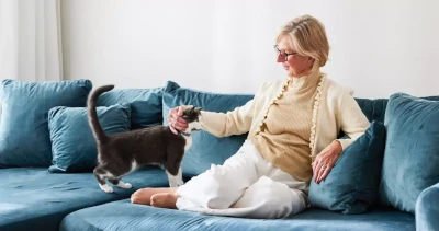 Kvinna i soffa klappar katt