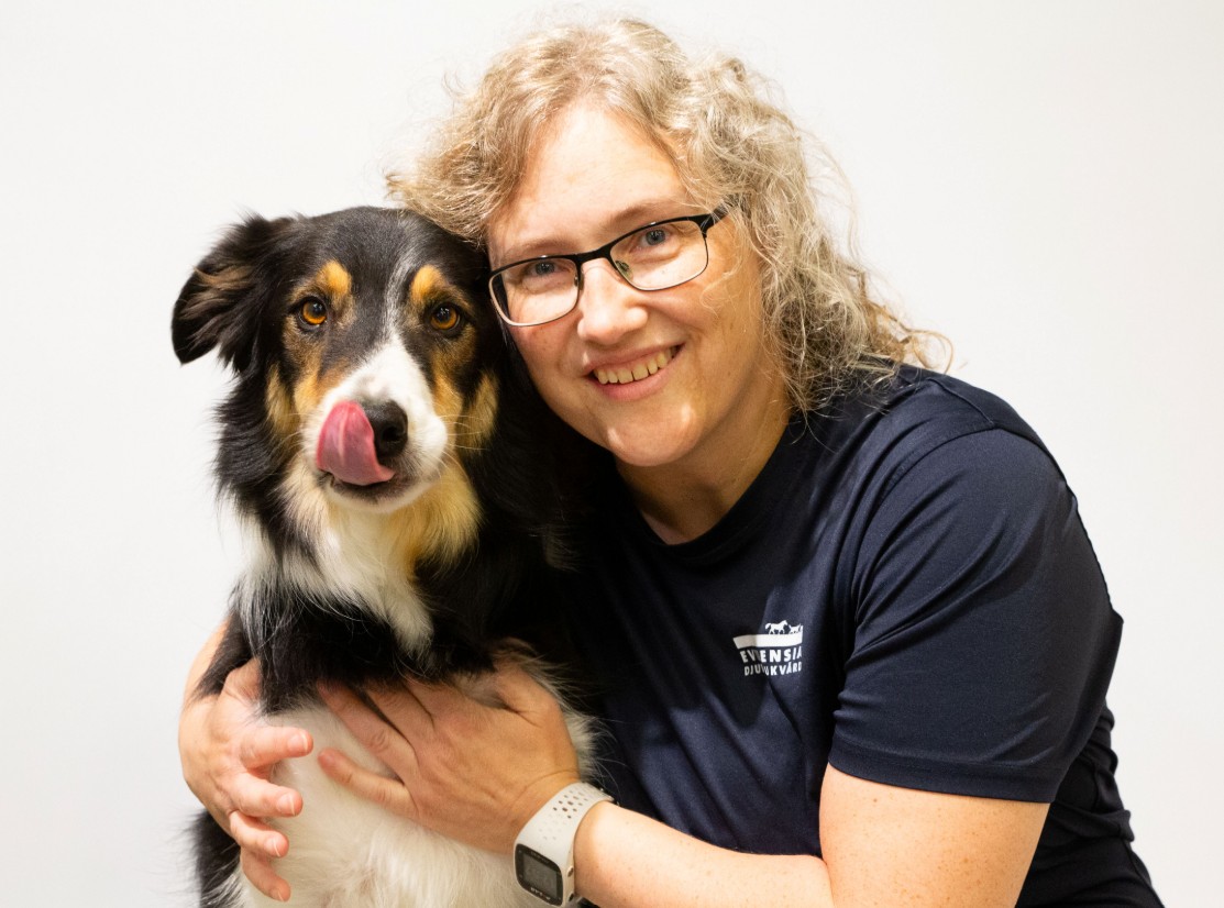 Emilia kramar en hund som slickar sig runt munnen